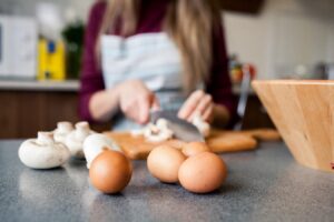 Unos huevos en la mesa de una persona preparando un almuerzo keto.