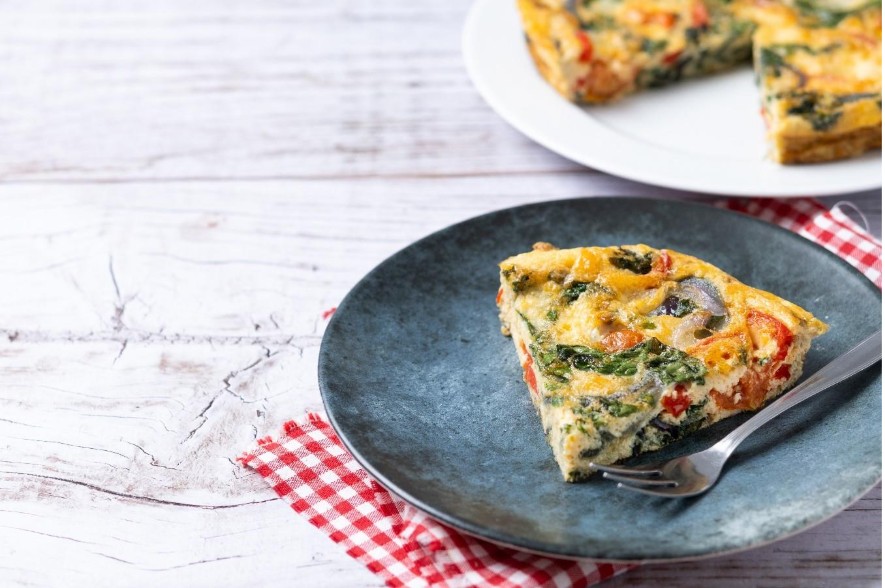Un plato con una tortilla de espinaca y huevo al horno