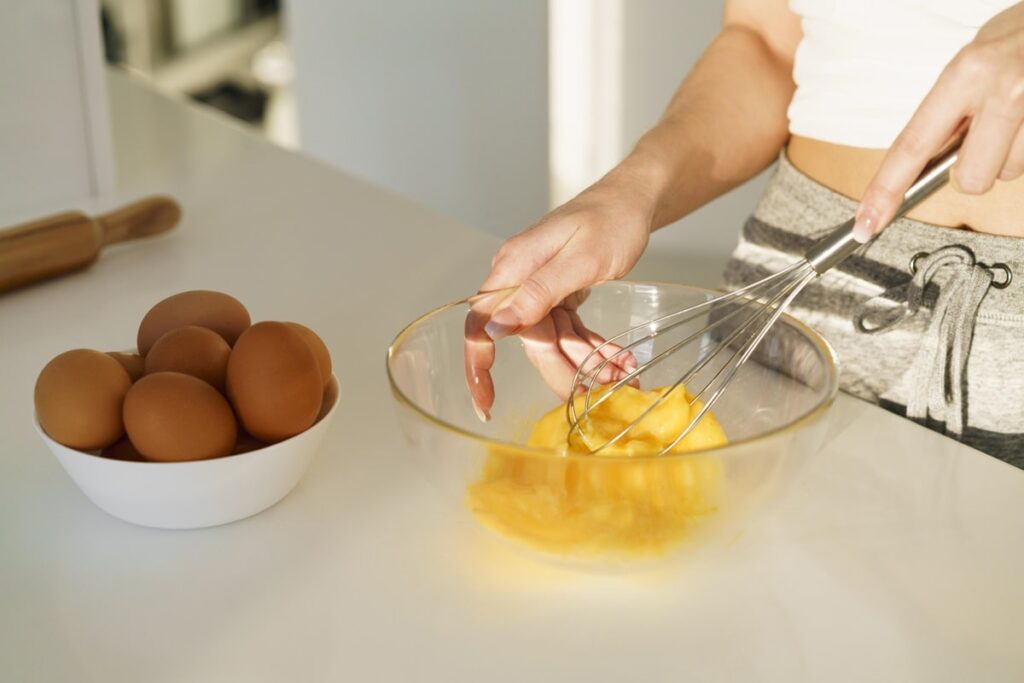 Una persona batiendo huevos para una tortilla de huevo
