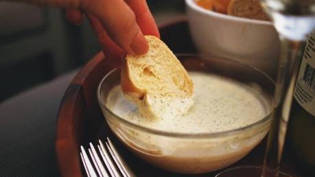 Persona untando un pan en mayonesa casera