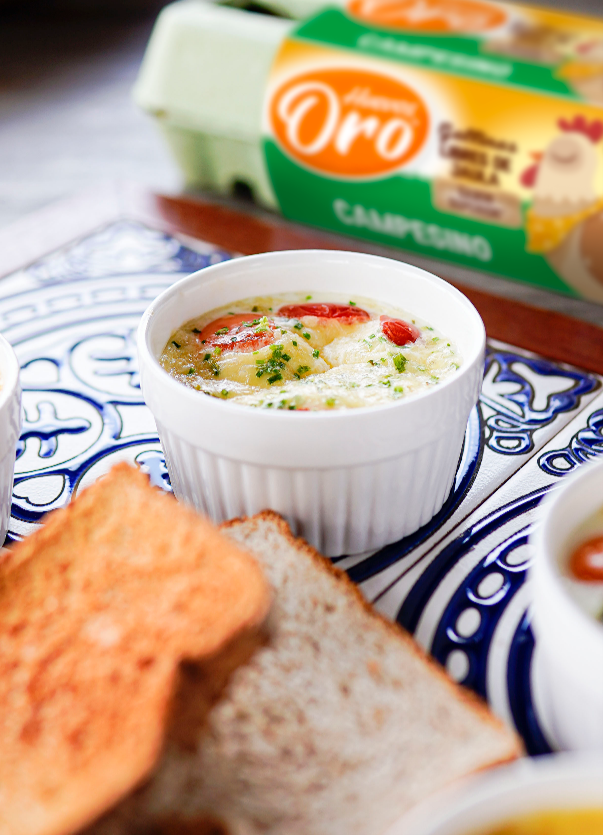 Huevo con queso servido en un recipiente con pan tostado