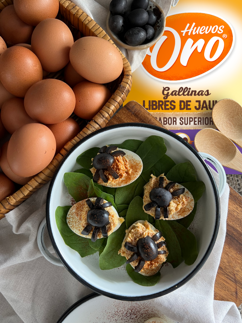 Huevos rellenos decorados con aceitunas sobre espinaca