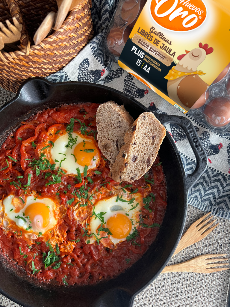 hakshuka con huevos sobre salsa de tomate y pan