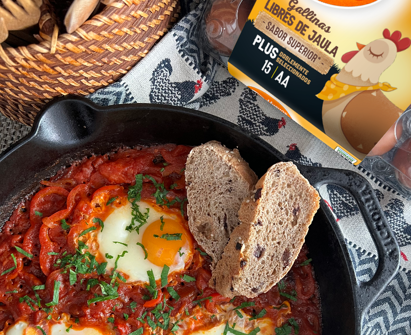 hakshuka con huevos sobre salsa de tomate y pan