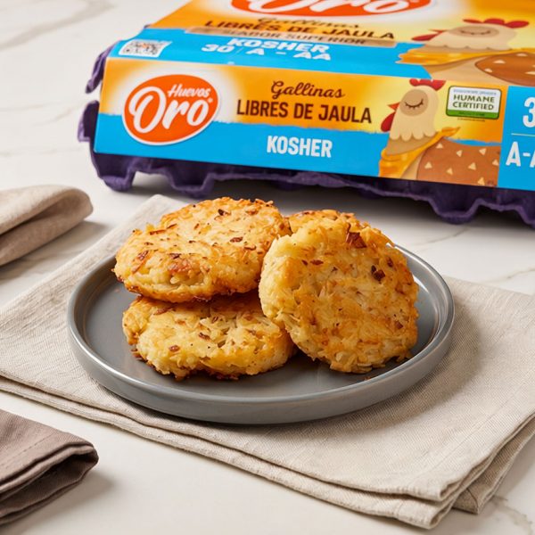 Tortitas de papa rallada o hash browns doradas y crujientes sobre un plato gris, con un empaque de Huevos Oro al fondo